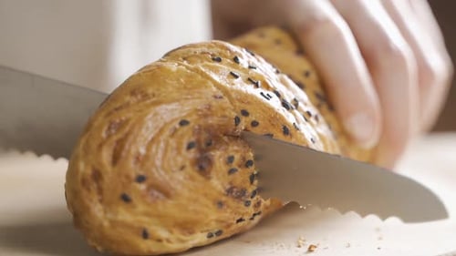 Closeup View of Slicing Bread on Wooden Cutting Board.