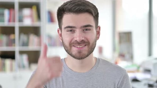 Man Gives Thumbs Up of Approval Indoors