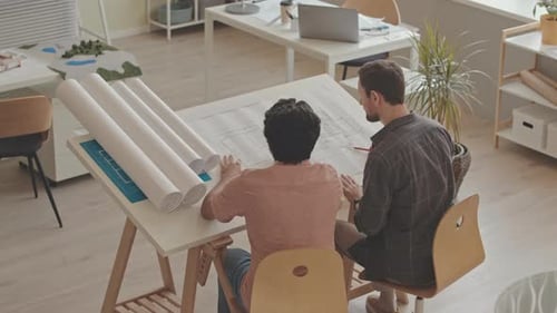 Architects Discussing Blueprints in Office