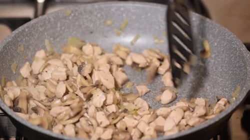 Fried Chicken Meat, Mushrooms and Onion Close Up on Frying Pan.