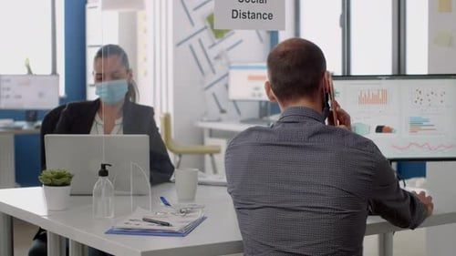 Employees Working in Office with Social Distance Dividers