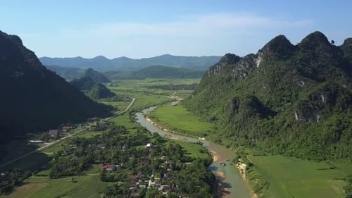 Flycam Follows River Road Running in Valley Between Hills