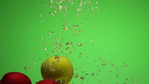 Group of Mixed Red and Green Apples Falling Into Water in Slow Motion