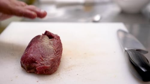 Close Up of Male Cook Hands Seasoning a Piece of Raw Beef Meat