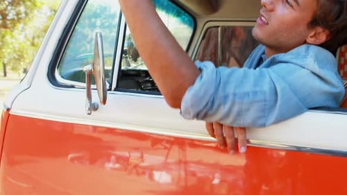 Young Man Using Smartphone Inside Vintage Vehicle