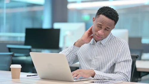 Young Man with Neck Pain Working at Computer