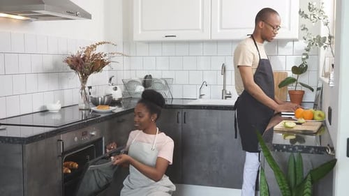Couple Baking Pastries and Chopping Fruit in Kitchen