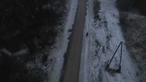 Einsamer Mann geht bei starkem Schneefall auf dem Weg