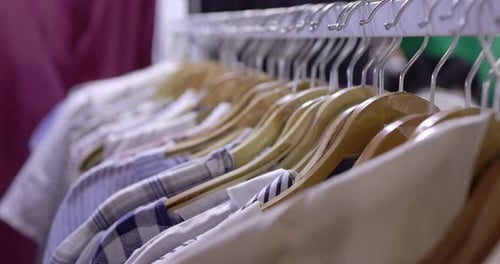 Close up cloth and dress hanging with rack in mall shop or cloth store.