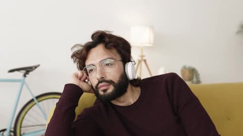 Man Relaxing on Couch with Headphones Indoors