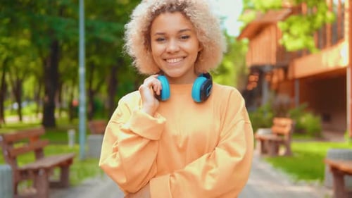 African Woman Walks in the Park and Smiles Coquettishly