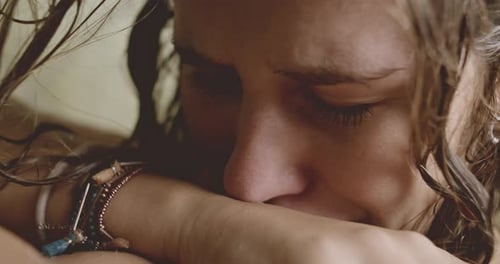 Distressed Young Woman Crying With Face in Arms