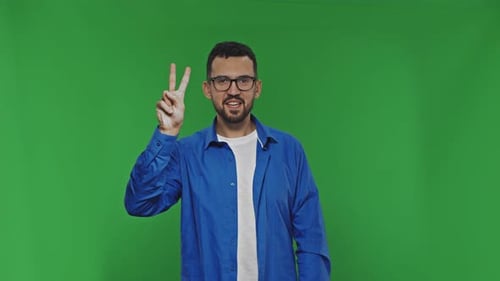 Smiling Young Adult with Peace Sign on Green Screen