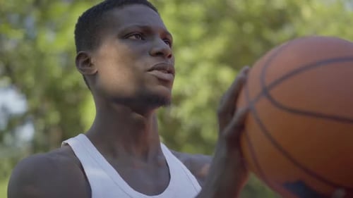 Close-up of Concentrated African American Sportsman Throwing Ball Into Basketball Hoop