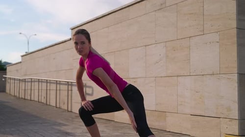 Sportswoman is Doing Physical Exercise Outdoors in City in Morning