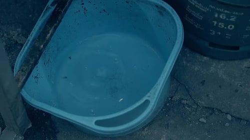 Las gotas de agua caen en una gran cuenca azul con agua limpia