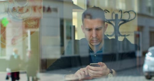 Man Using Smartphone Drinking Coffee in Cafe Texting Sharing Messages on Social Media Enjoying