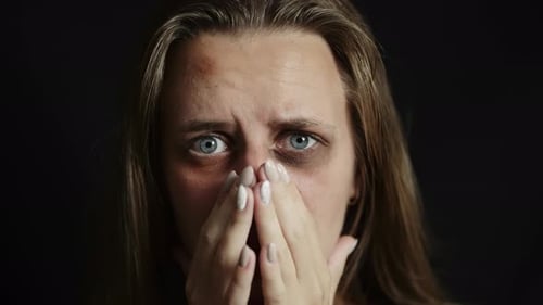 A Sad Beaten Up Woman with Wounds on Face is Looking at Camera