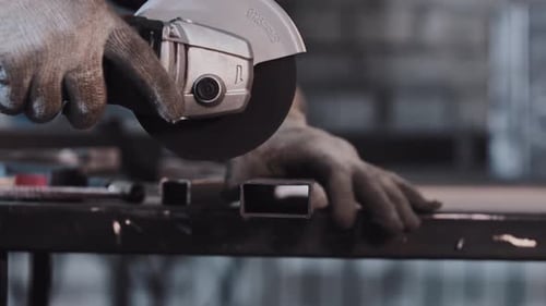Manufacturing Plant Man Worker Cutting the Part of Metal Detail with Angle Saw