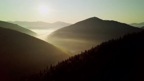Picos de montaña y cielo matutino con nubes en movimiento suave
