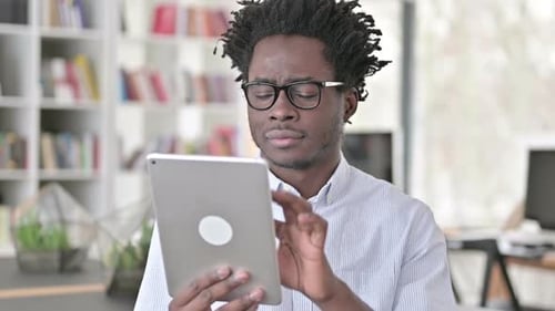 Young Adult Works On a Tablet Indoors