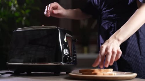 Toaster with Bread Slices Being Placed Inside