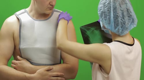 Doctor Reviews X-Ray With Patient in Studio