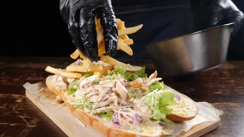 Chef Prepares Large Chicken and Fries Sandwich