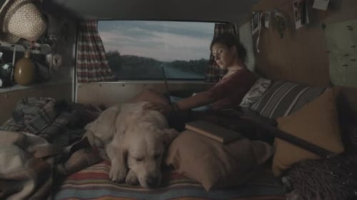 Woman Relaxing With Dog Inside of Recreational Vehicle