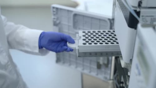 Scientist Placing Vials in Test Tube Rack