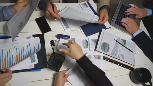 Top View Male and Female Hands of Colleagues Analyzing Financial Reports in Office. Business Team
