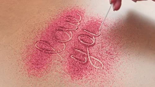 Drawing Love in Pink Glitter with a Hand