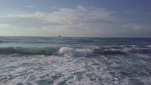 Aerial Sliding Trough Stormy Waves To Sea Tanker at Horizon