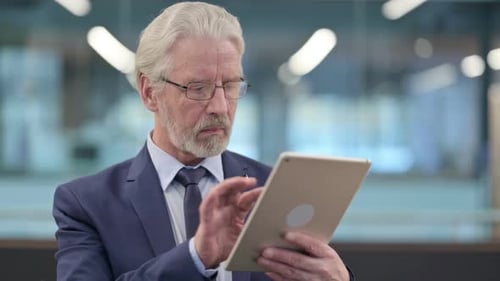 Senior Executive Using Tablet in Modern Office