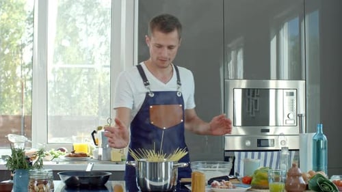 Man Cooking Spaghetti in Bright Modern Kitchen