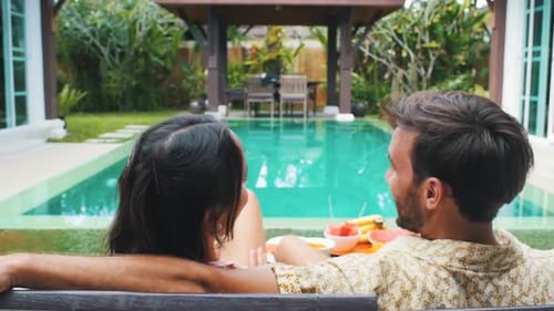 Couple Enjoying Relaxing Poolside Resort Vacation