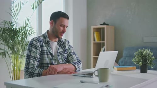 Man Using Laptop for Video Conference at Home