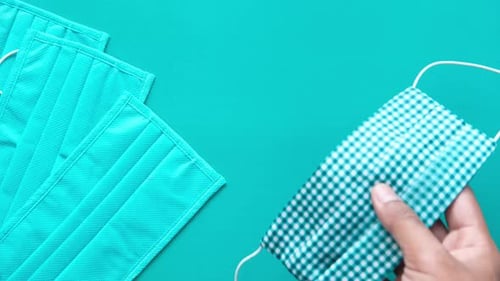 Man Hand Putting Homemade Face Mask on Green Background