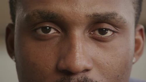 Extreme Close Up of an Unrecognisable African American Black Man Opening His Eyes an Looks Straight