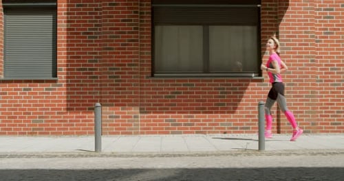 Athletic Young Woman Jogging in the City Early in the Morning