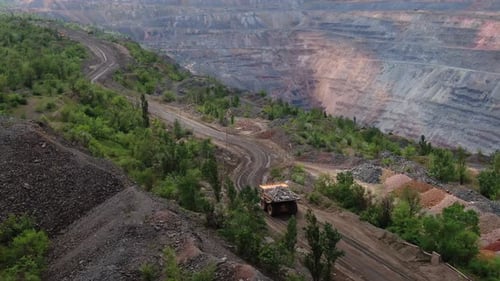 Drohnenaufnahmen eines Lastwagens, der Steine aus massivem Bergbau-Steinbruch transportiert