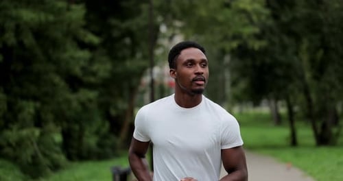 Man Running in Park on Public Green Background