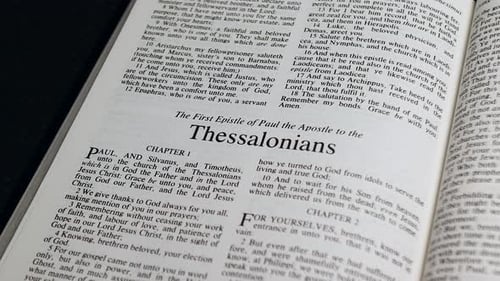Close Up Shot of Bible Page Turning to the book of First Thessalonians