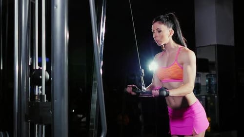 Sportliche Frau, die im Fitnessstudio auf dem Simulator trainiert.