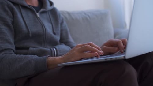 Close-up das mãos digitando no computador enquanto trabalha em casa