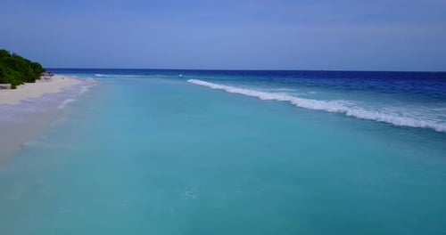 Daytime birds eye abstract shot of a sandy white paradise beach and blue water background in vibrant