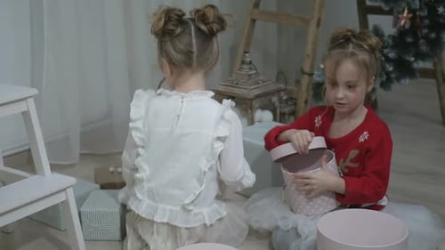 Excited Children Opening Christmas Gifts Together