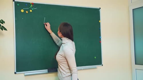 Woman Writes English Question on Chalkboard
