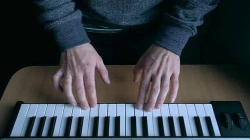 Hands Playing Electronic Keyboard Instrument Indoors