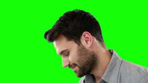 Nachdenklicher Mann steht vor grünem Hintergrund